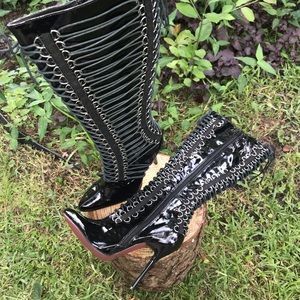 Solid black with black strings laced through chrome loops. Never worn.